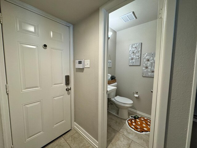 bathroom featuring toilet and tile patterned flooring