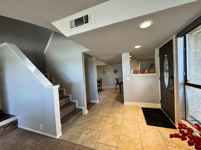 tiled entryway with a textured ceiling