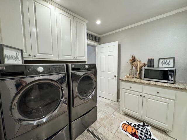 laundry room with cabinets, crown molding, and washer and dryer