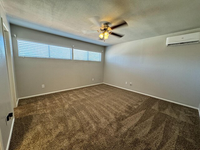 empty room featuring ceiling fan, plenty of natural light, a wall unit AC, and dark colored carpet