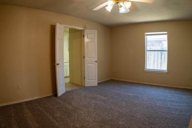 spare room featuring light colored carpet, a textured ceiling, and ceiling fan