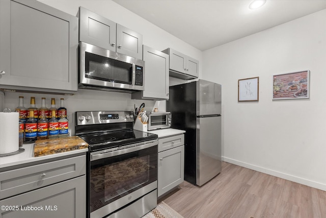 1203 N Evanston Ave, Lubbock, TX 79416 - kitchen with stainless steel appliances, gray cabinetry, light wood-style flooring, and light countertops