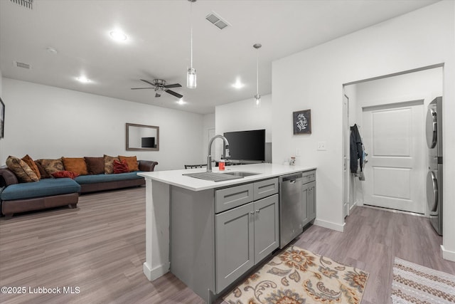 1203 N Evanston Ave, Lubbock, TX 79416 - kitchen with stacked washer and clothes dryer, gray cabinets, a peninsula, stainless steel dishwasher, and light wood-style flooring