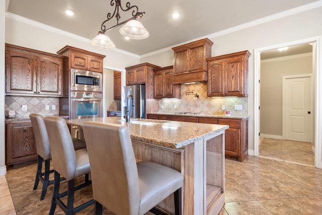 kitchen with a sink, appliances with stainless steel finishes, a breakfast bar, and crown molding