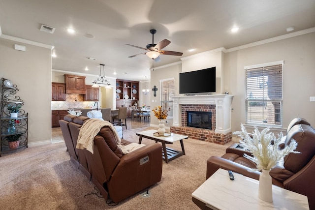 living area with visible vents, light carpet, ornamental molding, a brick fireplace, and ceiling fan