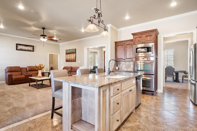 kitchen featuring a breakfast bar, a sink, stainless steel appliances, light carpet, and open floor plan