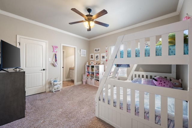 carpeted bedroom with baseboards, a ceiling fan, ensuite bath, and crown molding