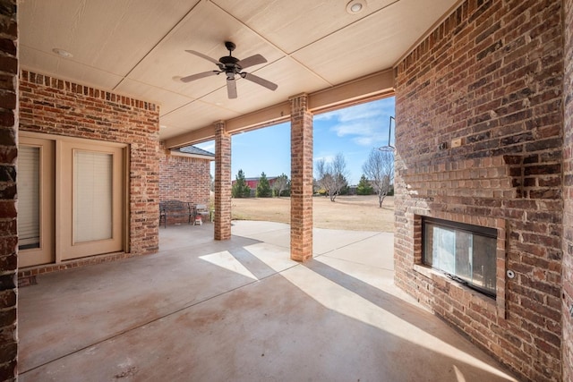 view of patio with a ceiling fan and an outdoor brick fireplace