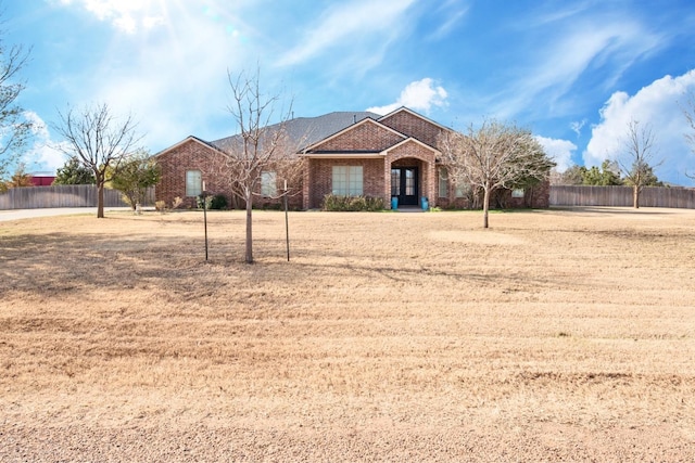 view of front of home featuring brick siding and fence