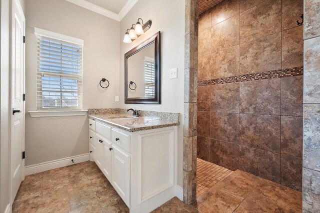 bathroom with vanity, tiled shower, a wealth of natural light, and ornamental molding