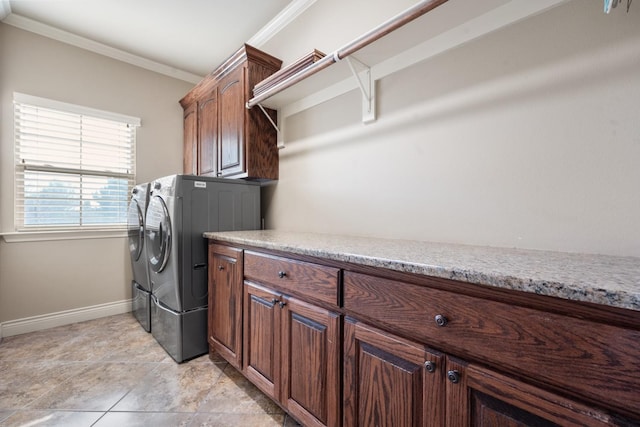 washroom featuring washer and dryer, baseboards, cabinet space, and ornamental molding