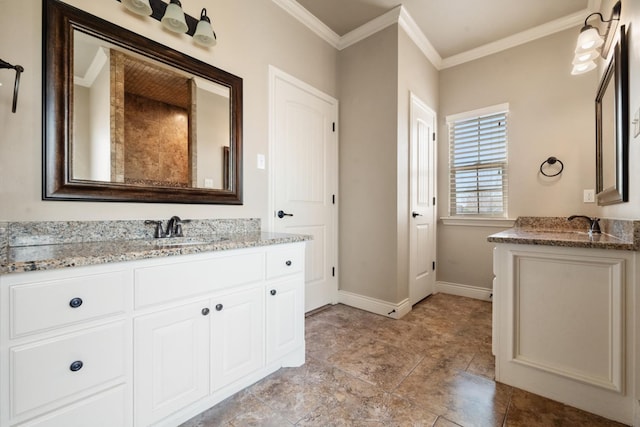 bathroom featuring ornamental molding, two vanities, baseboards, and a sink