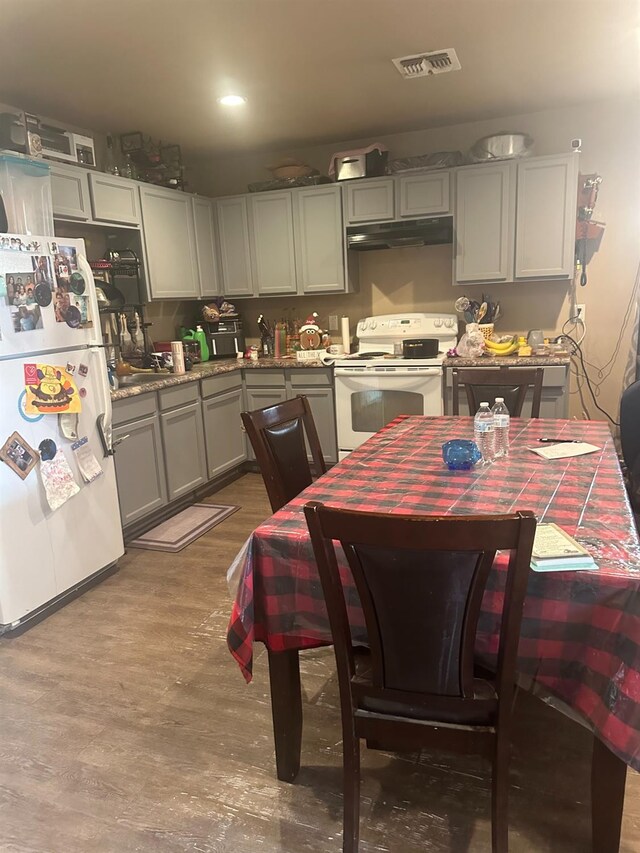 kitchen featuring hardwood / wood-style floors, gray cabinetry, and white appliances