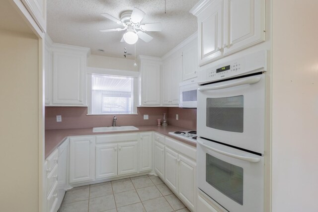 kitchen with white cabinetry, sink, and white appliances