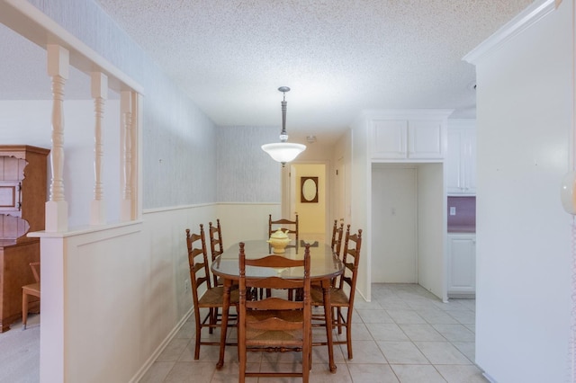 tiled dining room featuring a textured ceiling