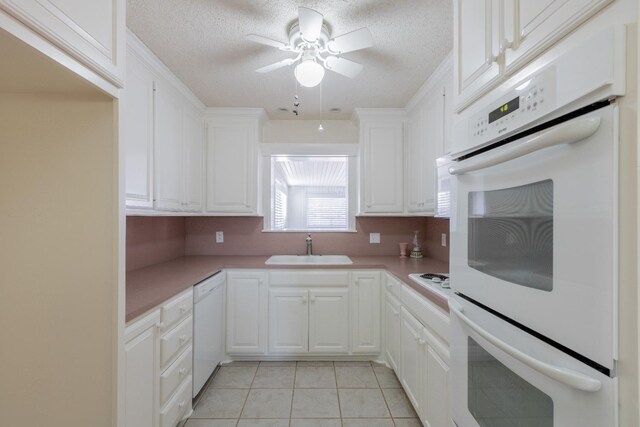 kitchen featuring white cabinetry, white appliances, light tile patterned flooring, and sink