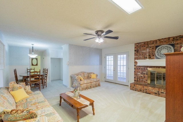 living room featuring a fireplace, ceiling fan, light carpet, a textured ceiling, and french doors