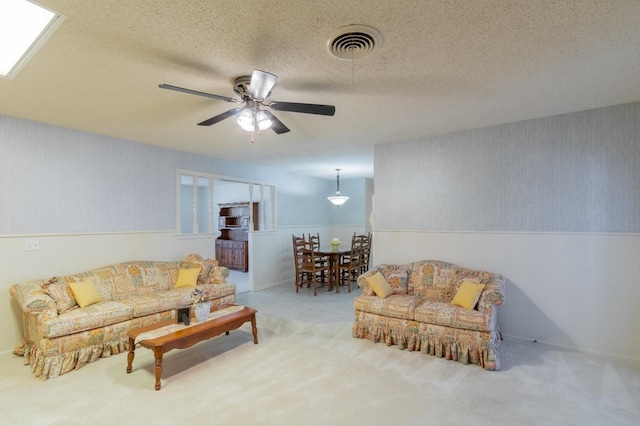 living room featuring ceiling fan, carpet, and a textured ceiling