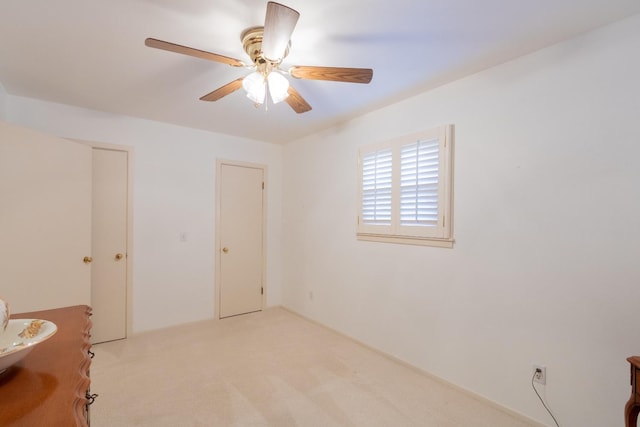 spare room featuring ceiling fan and light colored carpet