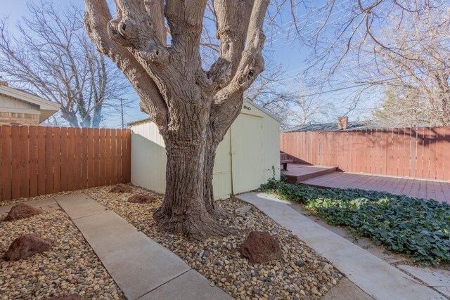 view of yard featuring a wooden deck and a storage unit