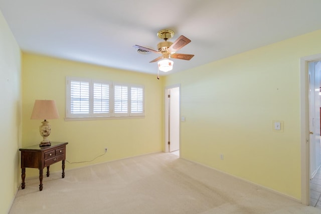 empty room featuring ceiling fan and light colored carpet