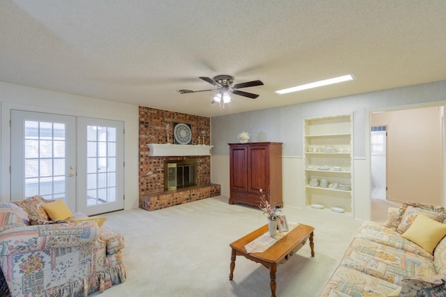 living room featuring french doors, light carpet, a textured ceiling, ceiling fan, and a fireplace