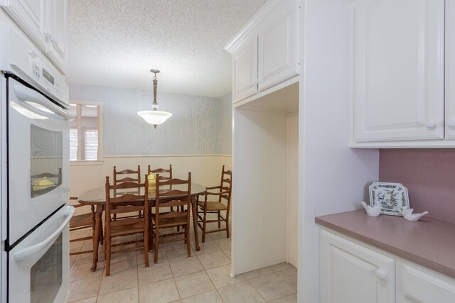 tiled dining space with a textured ceiling