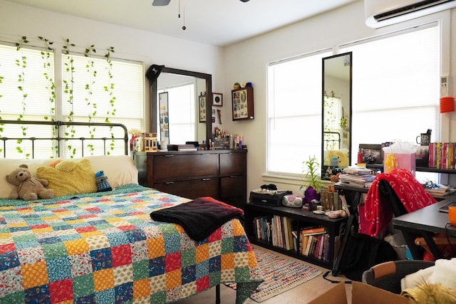 bedroom featuring ceiling fan and a wall unit AC