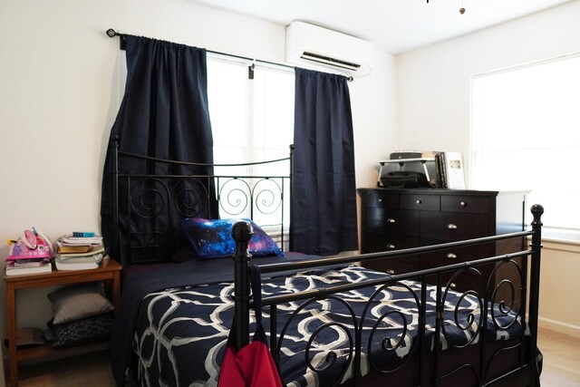 bedroom with multiple windows and a wall unit AC