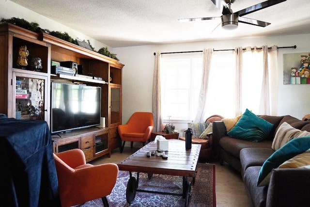 living room with a textured ceiling and ceiling fan