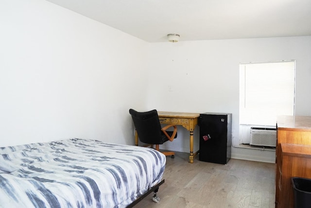 bedroom with cooling unit and light wood-type flooring