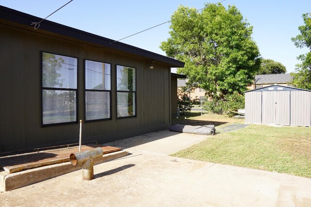 view of home's exterior with a shed, a patio area, and a lawn