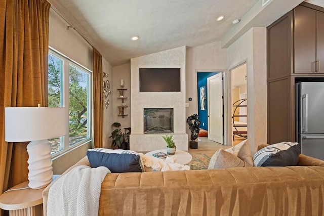 living room with a large fireplace, recessed lighting, wood finished floors, and lofted ceiling