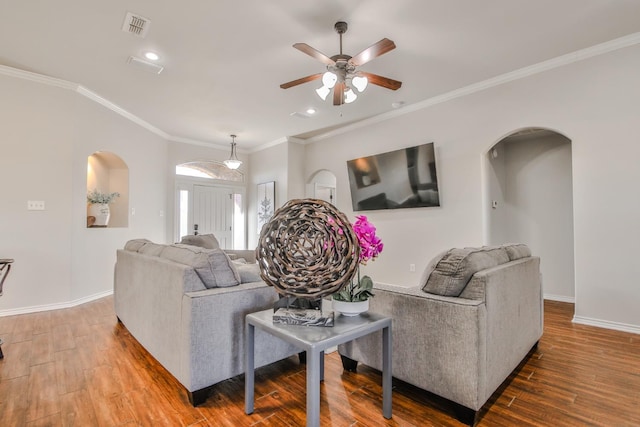 living room with hardwood / wood-style flooring, ceiling fan, and ornamental molding