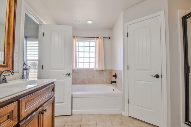 bathroom featuring a tub to relax in, tile patterned flooring, and vanity