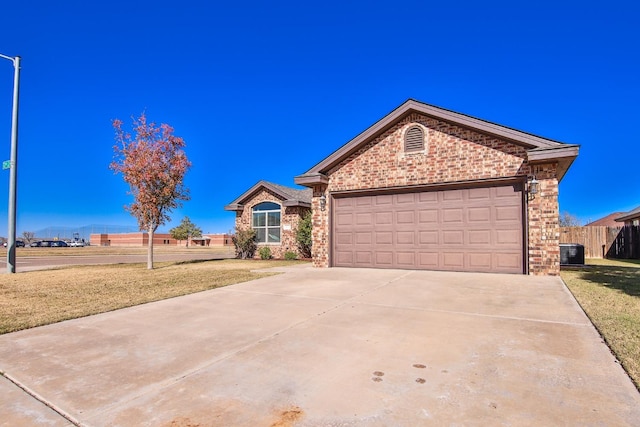 ranch-style home featuring a garage, central air condition unit, and a front lawn