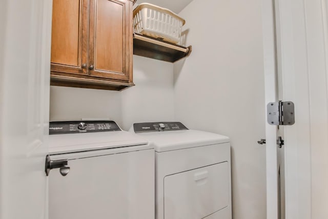 laundry room featuring cabinets and washer and clothes dryer