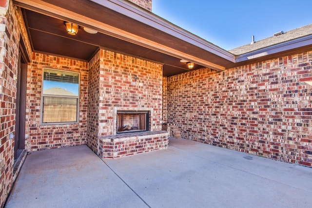 view of patio with an outdoor brick fireplace