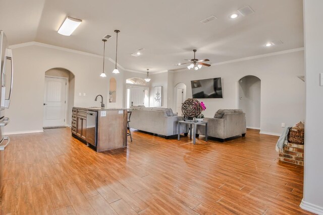 interior space featuring sink, crown molding, ceiling fan, light hardwood / wood-style floors, and vaulted ceiling