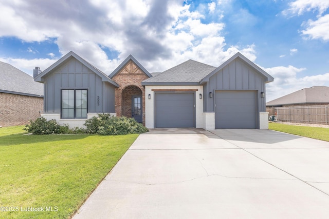 5005 Prentiss Ave, Lubbock, TX 79407 - view of front of house with board and batten siding, an attached garage, brick siding, driveway, and roof with shingles