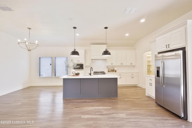 5005 Prentiss Ave, Lubbock, TX 79407 - kitchen with stainless steel fridge, light wood finished floors, light countertops, white cabinets, and recessed lighting