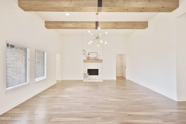 5005 Prentiss Ave, Lubbock, TX 79407 - unfurnished living room featuring light wood-type flooring, a chandelier, beamed ceiling, a fireplace, and recessed lighting