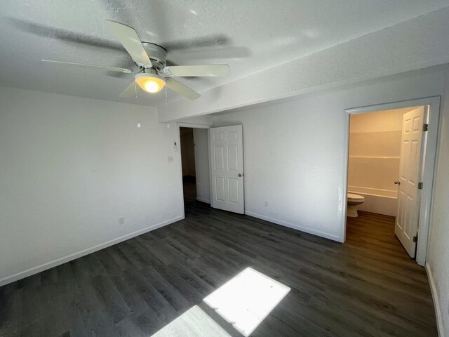 unfurnished bedroom featuring dark hardwood / wood-style flooring, a textured ceiling, ceiling fan, and ensuite bathroom