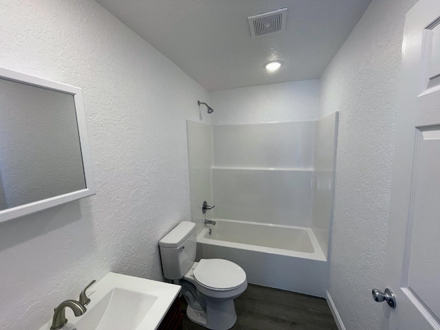 full bathroom featuring hardwood / wood-style flooring, washtub / shower combination, vanity, and toilet