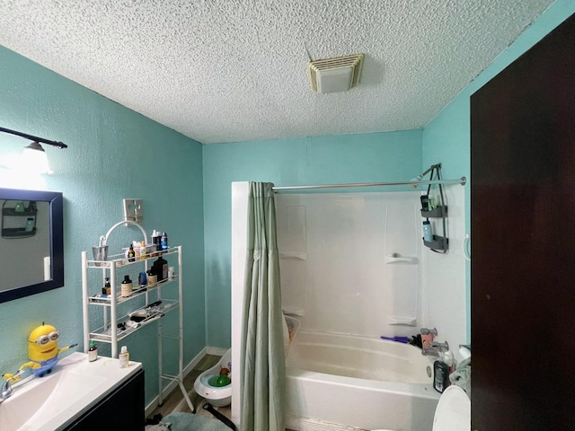 bathroom featuring vanity, shower / bathtub combination with curtain, and a textured ceiling