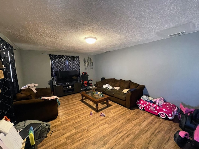 living room with light hardwood / wood-style floors and a textured ceiling