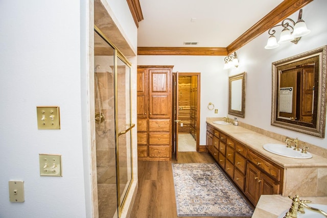 bathroom with vanity, an enclosed shower, crown molding, and wood-type flooring