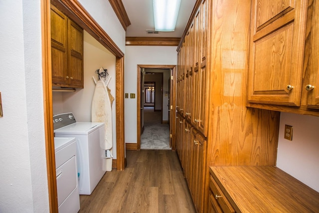 laundry area with cabinets, ornamental molding, light wood-type flooring, and independent washer and dryer