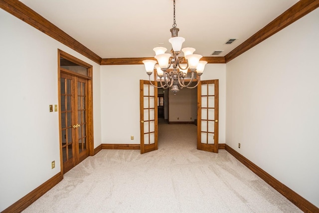 unfurnished dining area featuring ornamental molding, french doors, a chandelier, and carpet flooring