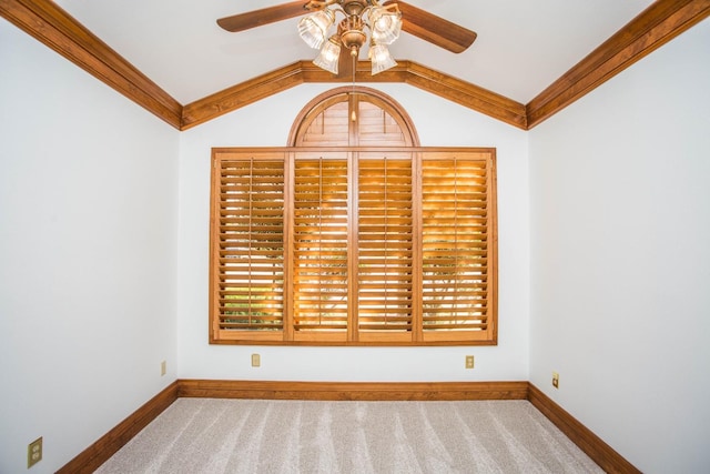 empty room with carpet floors, ornamental molding, ceiling fan, and vaulted ceiling